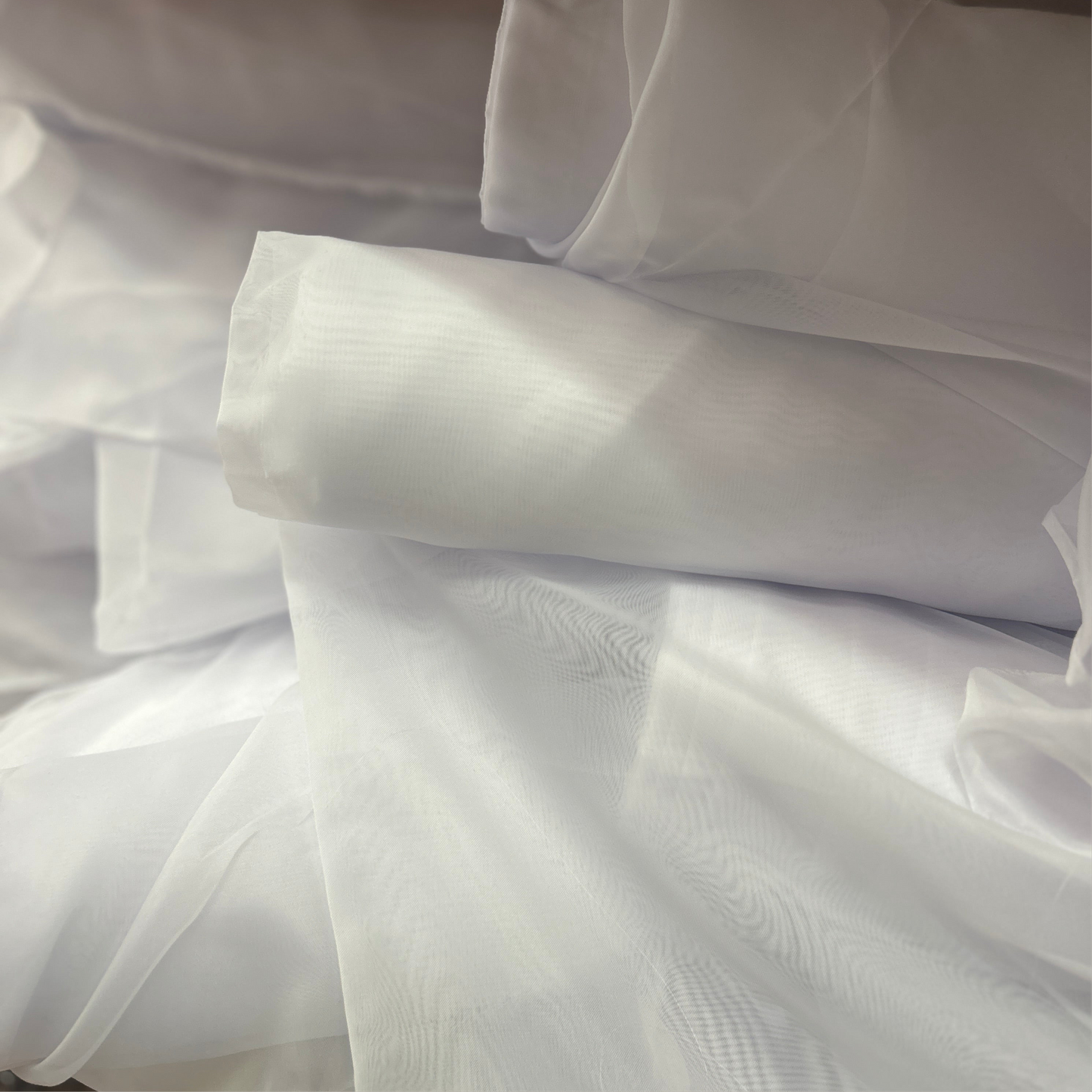 white voile fabric folded neatly showing sheer lightweight texture